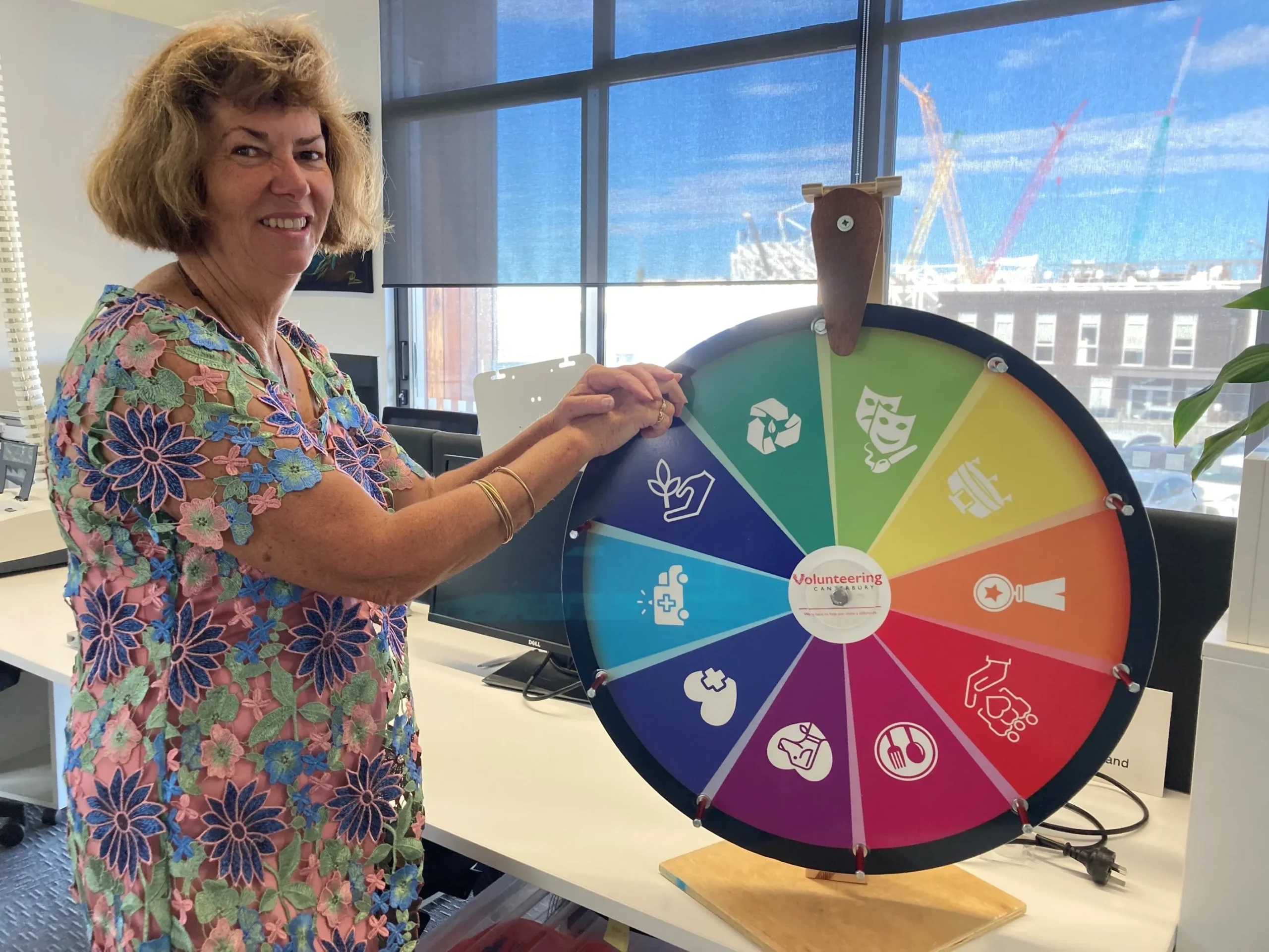 Glenda standing beside the Wheel of Opportunity